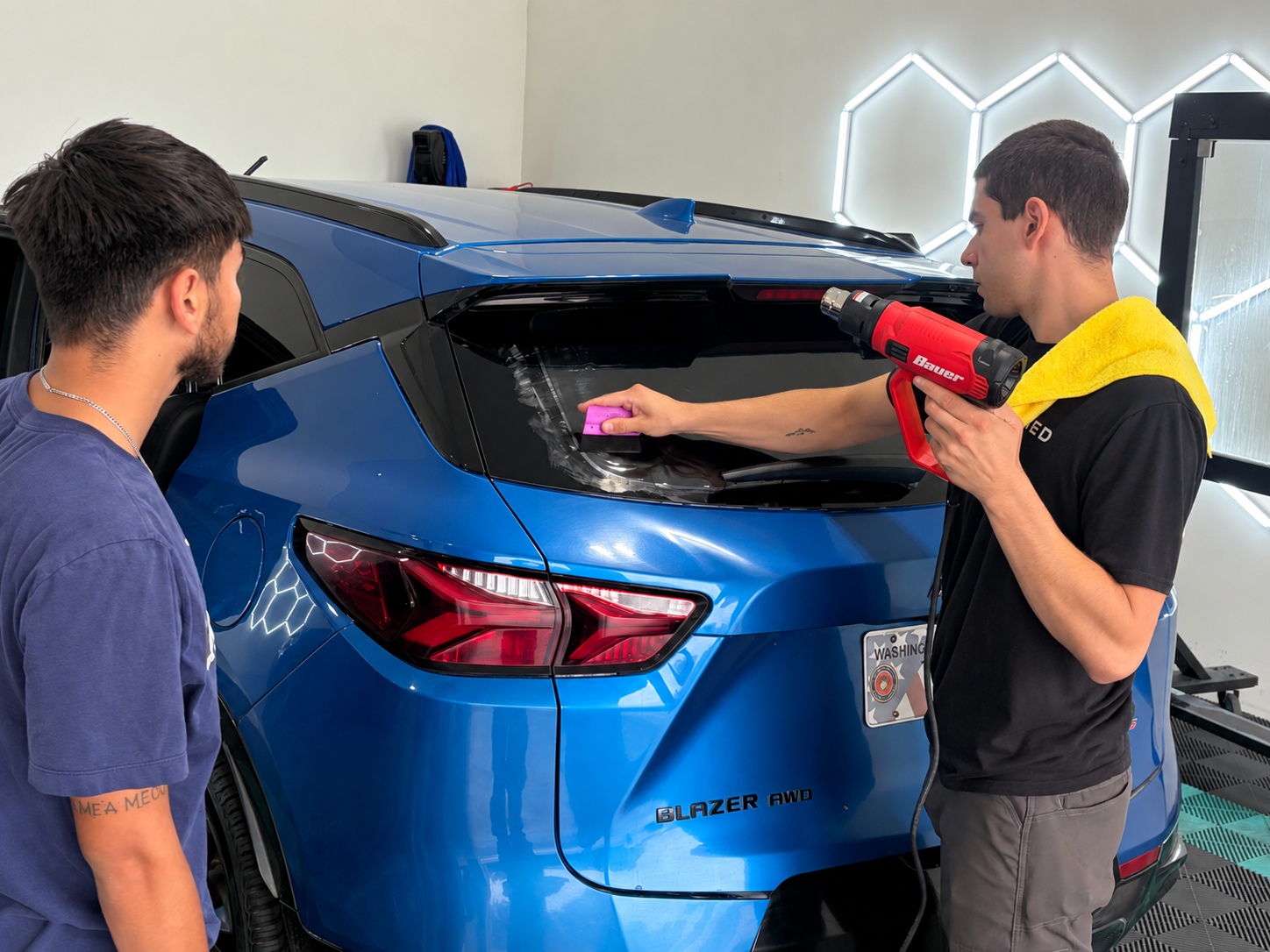 Hands-on window tint training at Refined Rides in Yakima: heat shrinking rear window film on a blue SUV